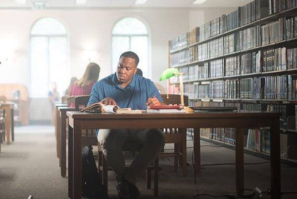 A student studies at a table in the Bruno Business Library